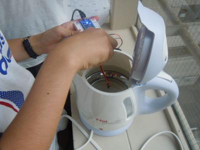 生徒が、ポットのお湯を「温度センサ」を使って測定中。
